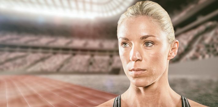 Close-up of serious female athlete against athletic track in a stadium 