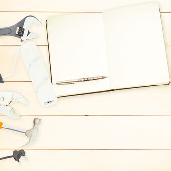 Tools and notepad on wooden background