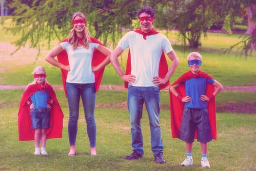 Happy family pretending to be superhero in the park