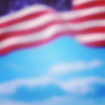 Close-up of American flag against cloudy sky background