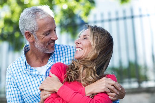 Smiling romantic mature couple standing in city