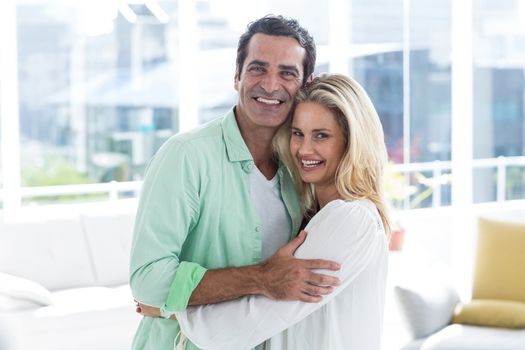 Portrait of mid adult romantic couple hugging at home