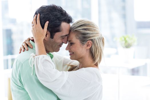 Mid adult romantic couple embracing at home