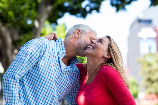 Romantic mature man kissing woman in city