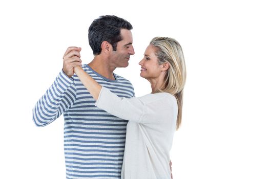Mid adult romantic couple dancing against white background
