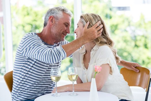 Romantic couple with white wine while sitting at restaurant