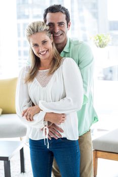 Portrait of mid adult romantic couple embracing at home