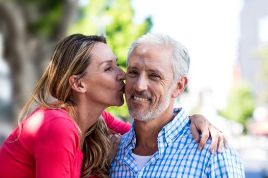 Romantic mature woman kissing man in city