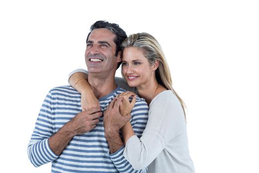 Mid adult romantic couple embracing against white background