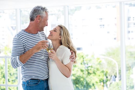 Smiling romantic mature couple with wine glasses while sitting at restaurant