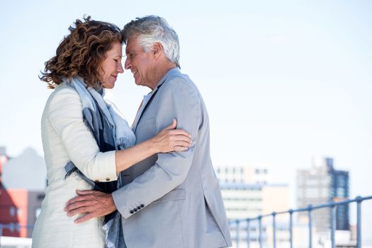 Side view of romantic mature couple standing against clear sky