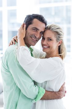 Portrait of mid adult  romantic couple embracing at home