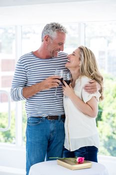 Romantic smiling mature couple with red wine while sitting at restaurant