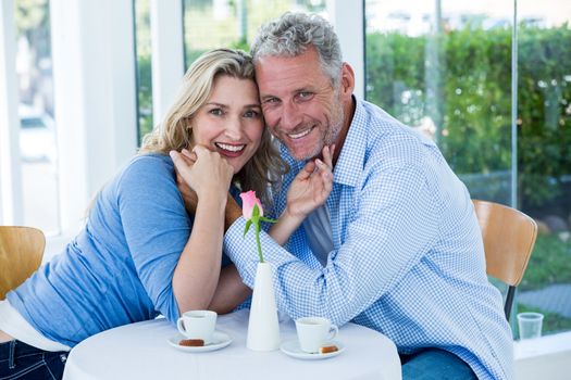 Portrait of romantic couple sitting at table in restaurant