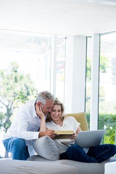 Romantic happy mature couple with gift box at home