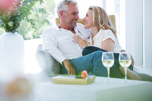 Romantic couple sitting on armchair at home