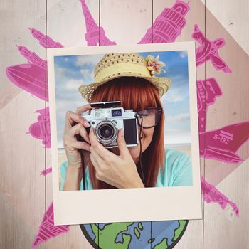 Portrait of a smiling hipster woman holding retro camera against colored wood