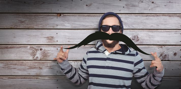 Portrait of happy hipster wearing sunglasses against artificial mustache