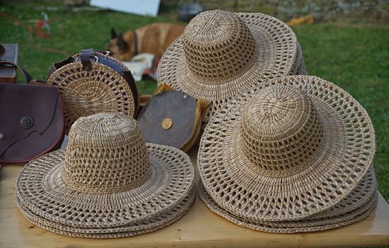 Old style straw hats for sale on wooden table