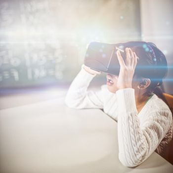 Little girl using virtual reality glasses at school