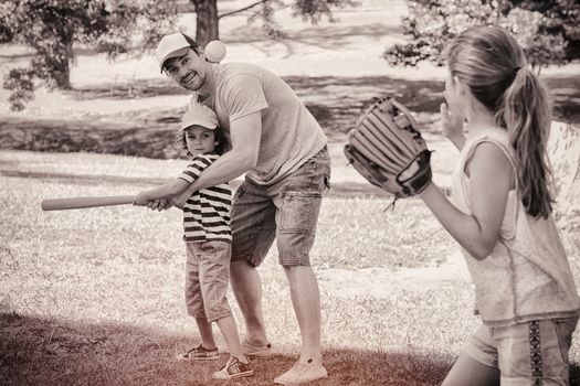 Father playing baseball with his children