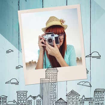 Portrait of a smiling hipster woman holding retro camera against colored wood
