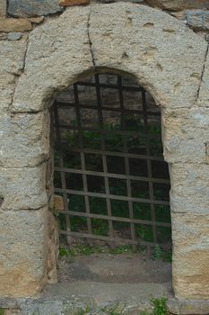 Stone archway and rustic metal gate representing dungeon entrance