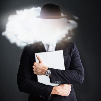 Mid section of businessman holding computer  against grey background