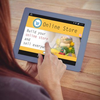 Screen of an online store against over shoulder view of hipster woman using tablet
