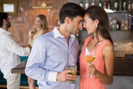 Romantic young couple holding wine glasses in restaurant