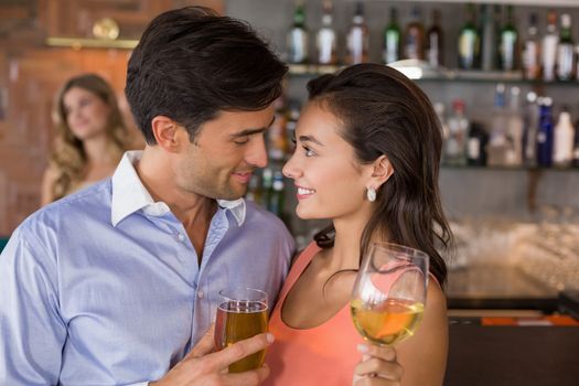 Romantic young couple holding wine glasses in restaurant