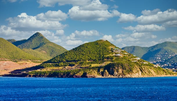 The coast off a tropical island with green islands rising from the blue sea