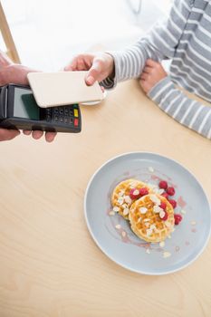 Woman making payment through NFC in cafeteria