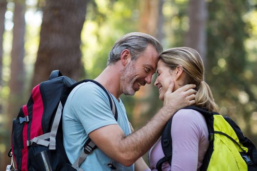 Romantic hiker couple embracing each other in forest