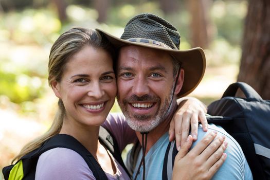 Romantic hiker couple embracing each other in forest