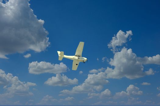 A small white plane from below against a blue sky