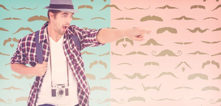 Surprised man with backpack pointing against composite image of mustaches