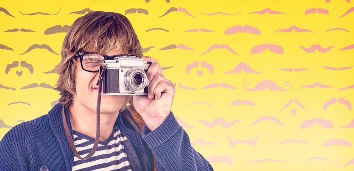 Hipster taking pictures with an old camera  against composite image of mustaches