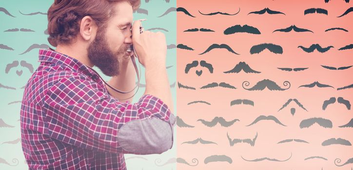 Side view of hipster photographing with camera against composite image of mustaches