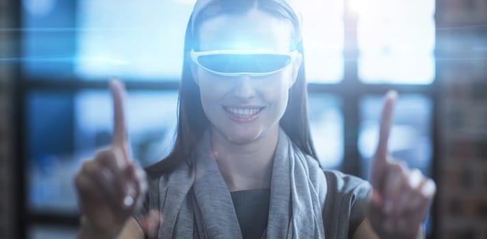 Smiling businesswoman gesturing while using virtual reality headset in creative office