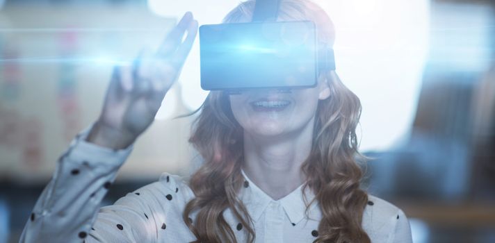 Smiling woman wearing virtual reality glass in office