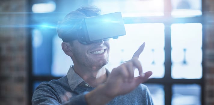 Young businessman gesturing while using virtual reality headset in creative office