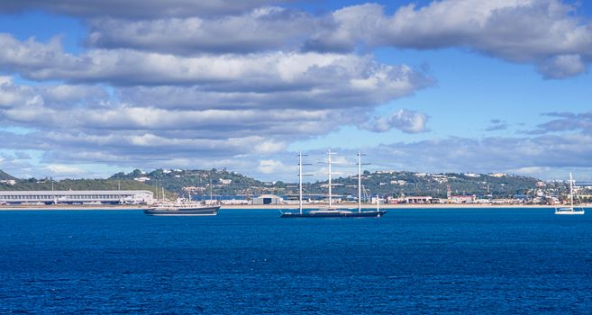 The coast off a tropical island with sailing yachts