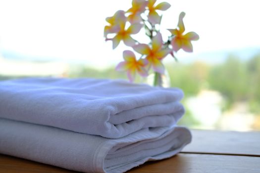 Close up of Stack of towels with fresh Plumeria flowers decor in a hotel room. 