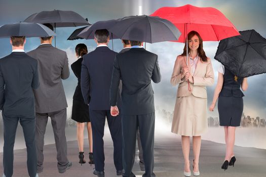 Business people holding umbrellas against city background