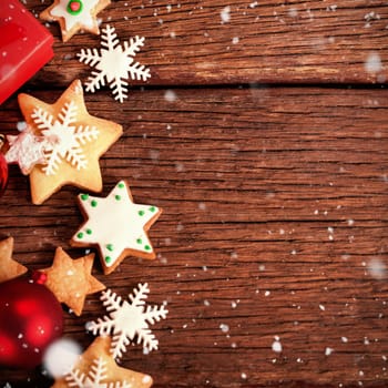 Snow falling against cookies with christmas decorations