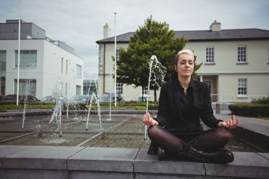 Businesswoman practicing yoga in office campus