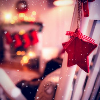 Snow falling against christmas decoration hanging on chair