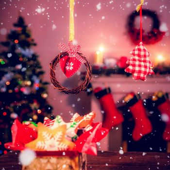 Snow falling against christmas gingerbread cookies and christmas ornaments