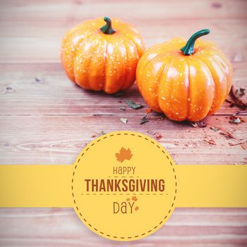 Happy thanksgiving against high angle view of two pumpkins on table